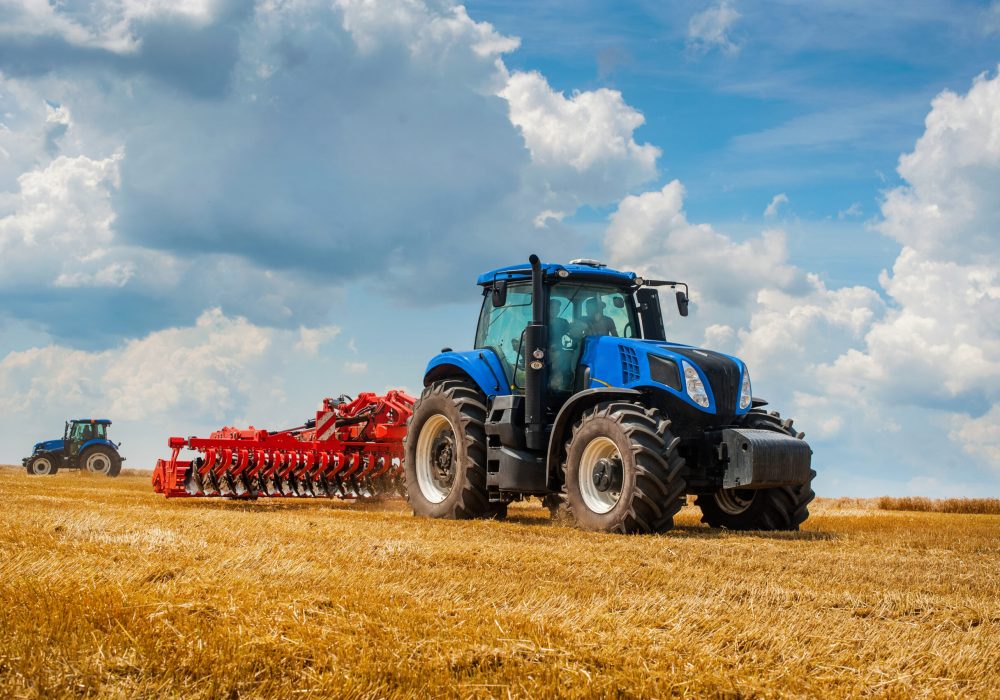 Nastasiv,Ternopil,Ukraine - July 25, 2019: Presentation of agricultural technology - New Holland, new blue tractor in motion at demonstration field site at agro exhibition working with harrows.